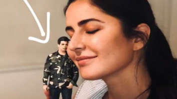 Katrina Kaif poses with a miniature doll of Karan Johar