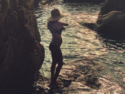Lisa Haydon flaunts her third baby bump in a bikini as she poses on a beach