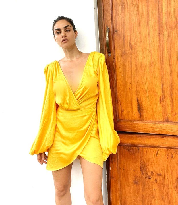 Gabriella Demetriades is a ray of sunshine in plunging neckline yellow mini wrap dress