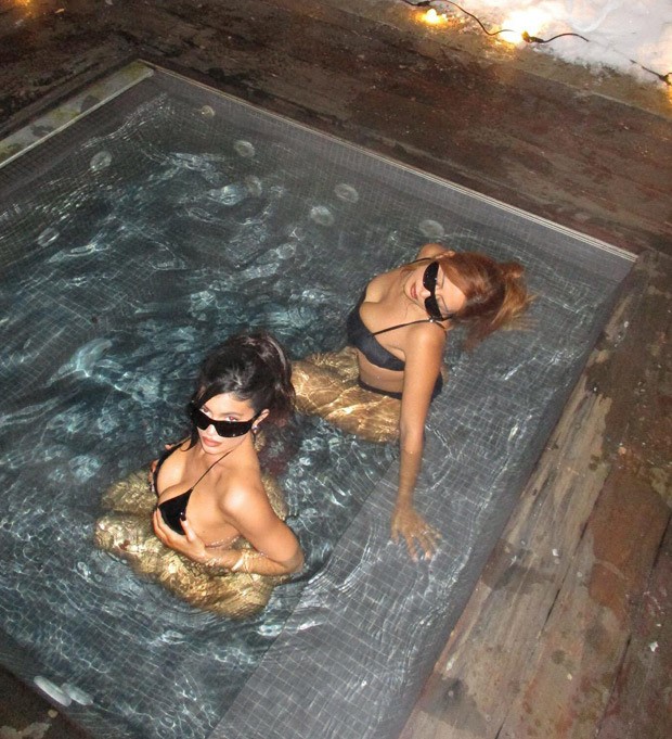 Kylie Jenner lounges with a friend in a hot tub at midnight while donning a tiny black bikini in Aspen's frigid weather