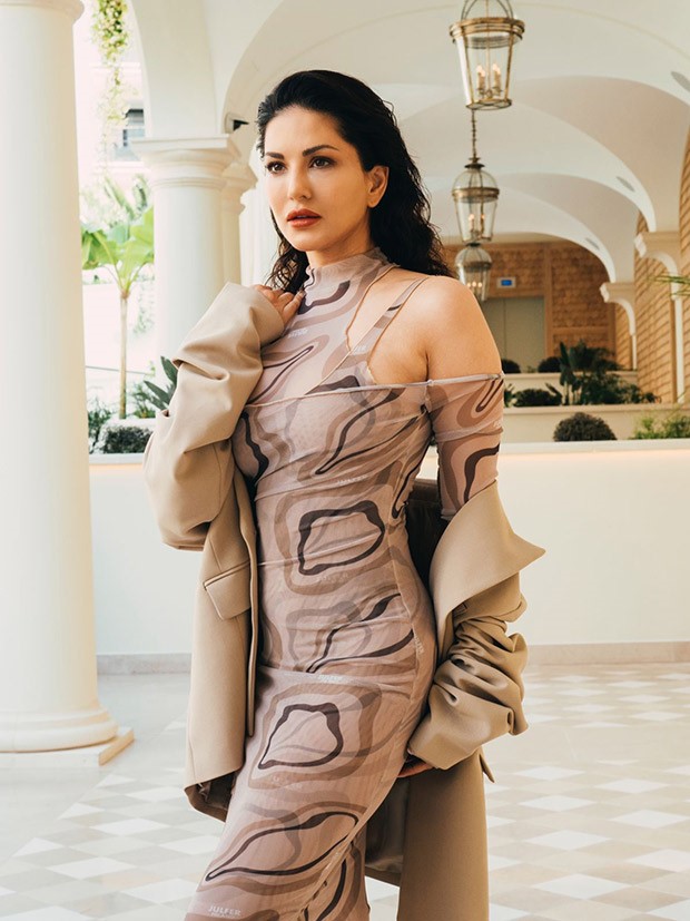 Cannes 2023: Sunny Leone mesmerizes in a sheer brown cut-out midi dress, accompanied by a chic beige overcoat