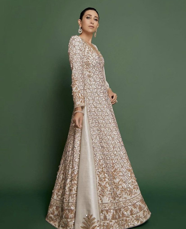 Karisma Kapoor is a vision of ethereal beauty in a white Manish Malhotra lehenga, adorned with a long jacket