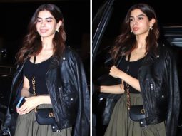 Khushi Kapoor elevates her airport fashion by infusing a stylish twist into wardrobe essentials, pairing a black top, a biker jacket, and a green pleated skirt