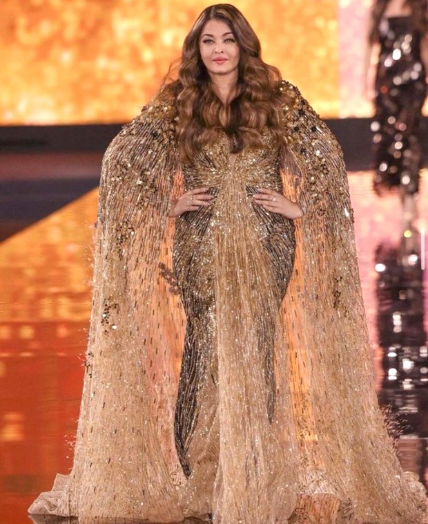 Aishwarya Rai Bachchan graces the Paris Fashion Week Ramp for L'Oréal in shimmery golden cape gown