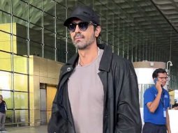 Arjun Rampal smiles as he poses for a picture with fans at the airport