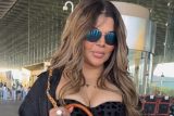 Rakhi Sawant carries a unique purse with her mom’s portrait, shows it to paps at the airport