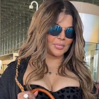 Rakhi Sawant carries a unique purse with her mom's portrait, shows it to paps at the airport